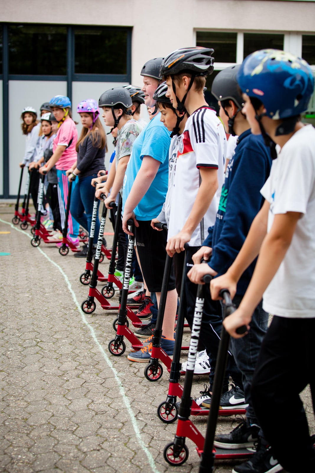 Kinder stehen mit ihren City Skate Wheel up Scootern an einer Startlinie