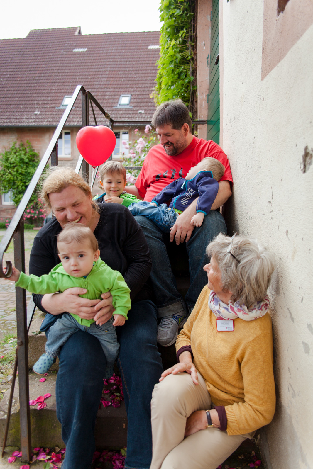 Eine Familie mit ihren Kindern sitzt auf einer Treppe