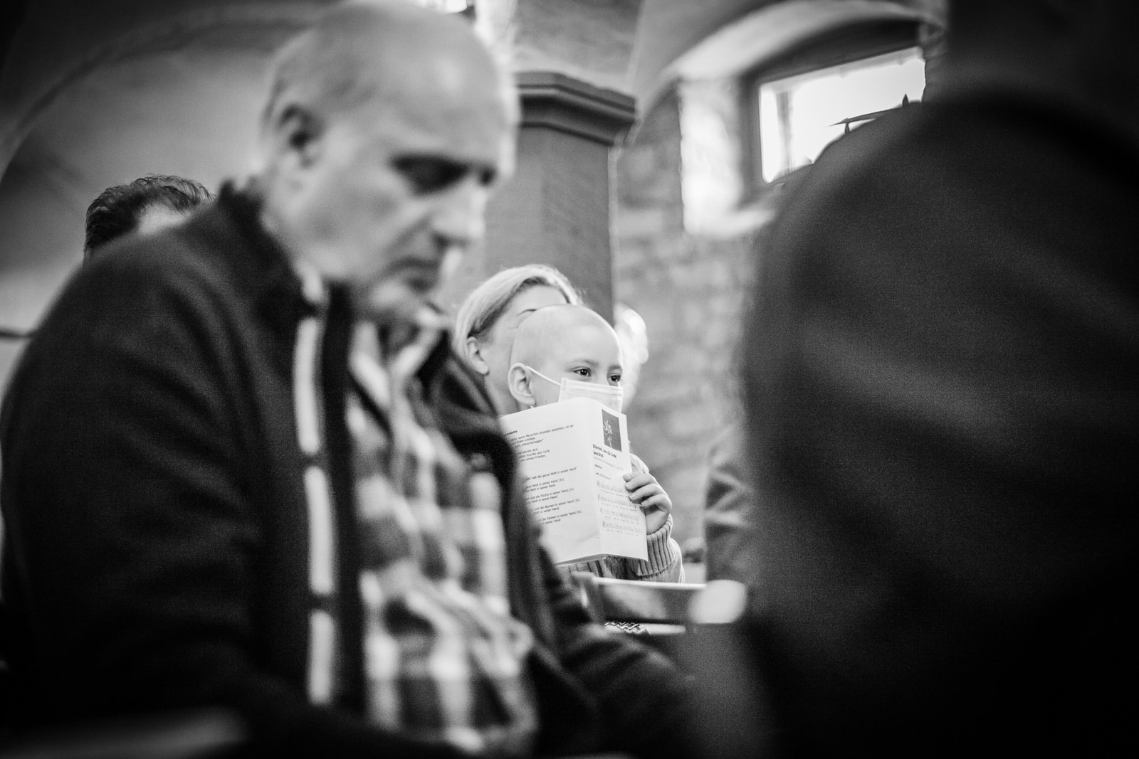 Ein Kind hört mit seinen Eltern beim Gottesdienst zu