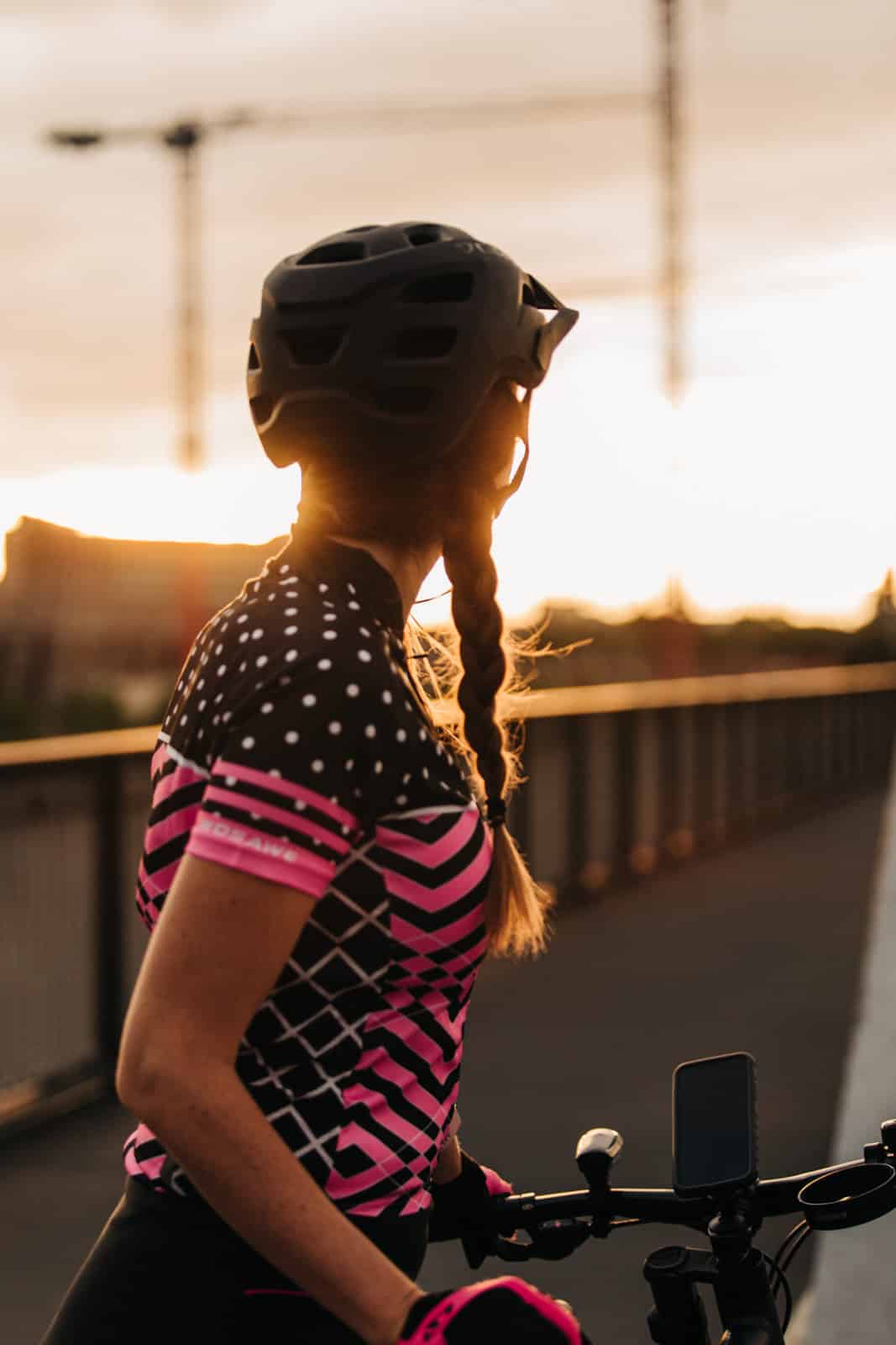 Frau schaut Sonnenuntergang mit Fahrrad an